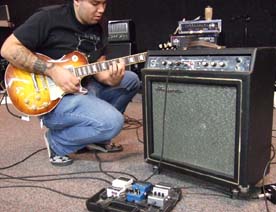 Program coordinator Bob Okamoto uses his new Gibson guitar to demonstrate vintage Ampeg amp and guitar pedals donated by BMF. [Photo by Tom Ineck]