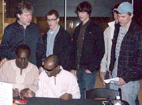 Bela Fleck (upper left) and African musicians sign CDs and talk with fans after the concert [Photo by Grace Sankey-Berman]