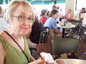 Mary Jane Gruba enjoys a beignet and cafe au lait at Cafe du Monde. [Photo by Tom Ineck]