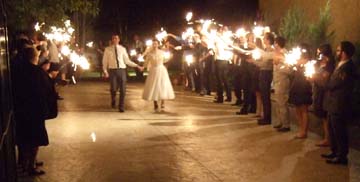 Newlyweds Phil Lienert and Lindsey Stranahan leave the reception between rows of well-wishers waving sparklers. [Photo by Tom Ineck]