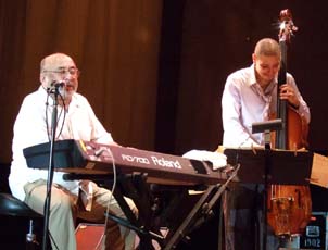 Eddie Palmieri sings as bassist Luques Curtis plays. [Photo by Tom Ineck]